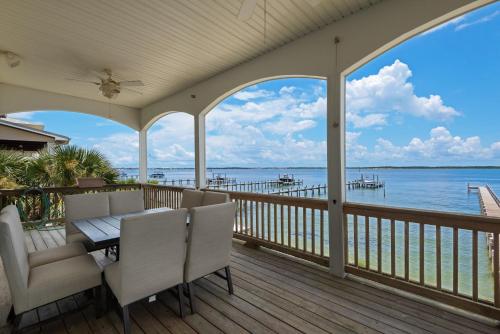 a porch with a table and chairs and a view of the water at Lets Do Sunset by Gulf Coast Getaways in Pensacola Beach