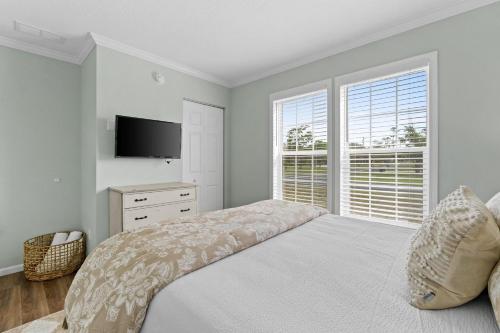 a bedroom with a bed and a tv and a window at Pet Friendly Beach House - Hakuna Matata by Panhandle Getaways in Port Saint Joe