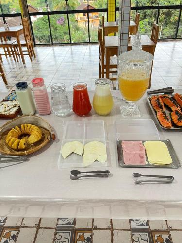 a table with plates of food and a jug of juice at Hotel Lumiar in Lumiar