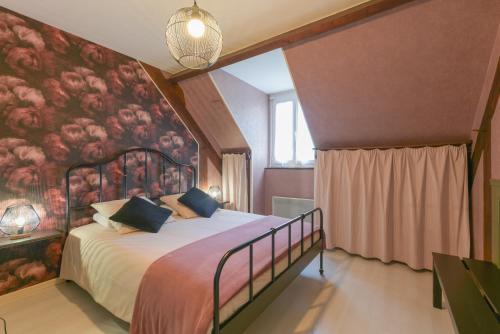 a bedroom with a large bed with a floral wall at Villa de la Douloustre in Montgaillard
