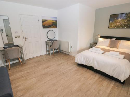 a bedroom with a bed and a table and a desk at Sycamore in Cowbridge