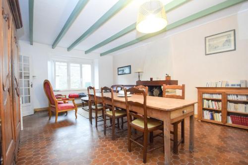 une salle à manger avec une table et des chaises dans l'établissement Maison de la mer à 6min des plages avec jardin, à Saint-Coulomb