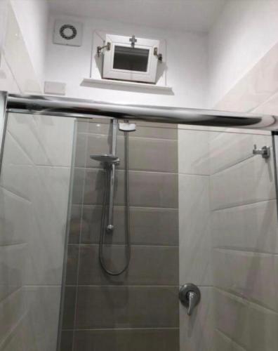 a bathroom with a shower with a microwave above it at La Terrazza in Marsala