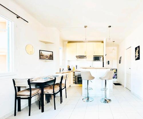 une cuisine avec une table et des chaises dans une pièce dans l'établissement Studio lumineux et spacieux Juan les pins, à Antibes