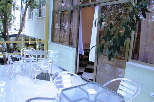 a patio with chairs and tables and a window at Hotel Lobelia in Addis Ababa