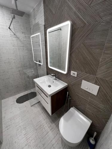 un bagno con lavandino, WC e specchio di Adas apartment a Vlorë