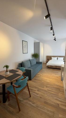 a living room with a couch and a table and a bed at Nova Central in Cluj-Napoca