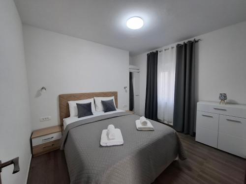 a bedroom with a bed with two white towels on it at Apartman Lazovic Prcanj in Kotor