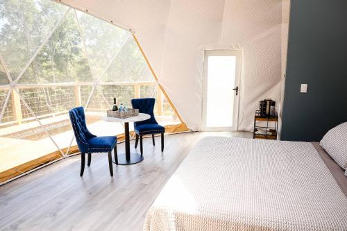 a bedroom with a bed and a table and chairs at Glamping Dome, Deck Cedar Hot Tub, Mountain View in Eureka Springs
