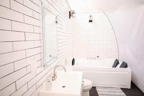 a white bathroom with a tub and a sink at Glamping Dome, Indoor Jacuzzi, Mountain View, Deck in Eureka Springs