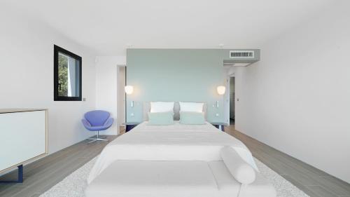 une chambre avec un lit blanc et une chaise bleue dans l'établissement Villa 888, à Roquebrune-sur Argens