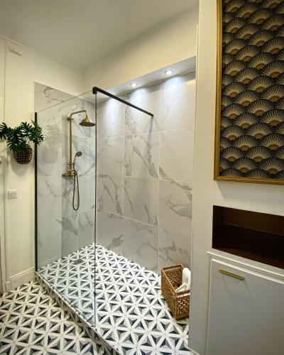 La salle de bains est pourvue d'une douche et de carrelage. dans l'établissement Grand appartement cozy et lumineux au centre d'Orleans, à Orléans