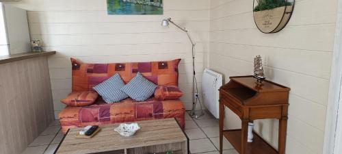 un salon avec un canapé et une table dans l'établissement Charmante maisonnette proche plage, à Châtelaillon-Plage