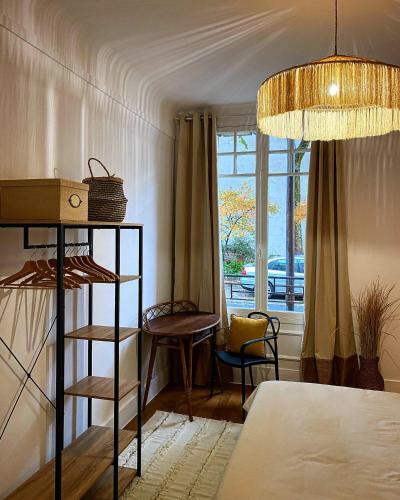 une chambre avec un lit, une table et une fenêtre dans l'établissement Grand appartement cozy et lumineux au centre d'Orleans, à Orléans