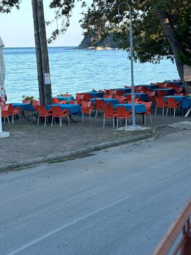 a row of tables and chairs next to the water at Studio Nikol koutsoupia in Kókkinon Nerón