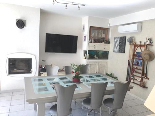une salle à manger avec une table et des chaises en verre dans l'établissement chambre d'hôtes villa tigre LA CIOTAT Quartier résidentiel, à La Ciotat