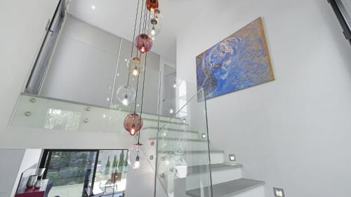 - un escalier en verre avec un lustre dans une maison dans l'établissement Villa 888, à Roquebrune-sur Argens