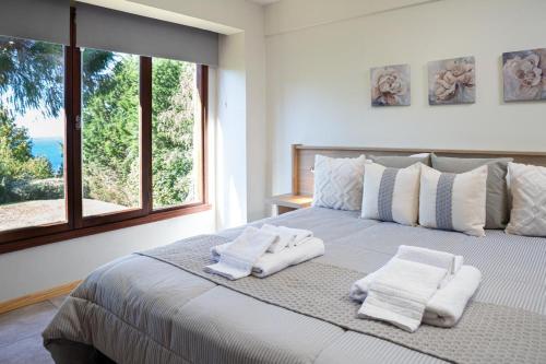 une chambre avec un grand lit avec des serviettes dessus dans l'établissement S&M Departamento 7, à San Carlos de Bariloche