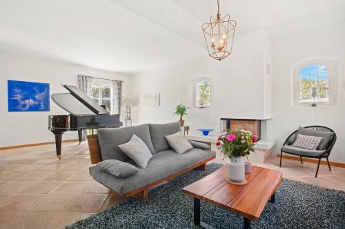 a living room with a couch and a piano at Mon Gîte en Provence avec piscine in Salernes