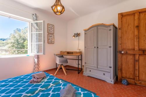 a bedroom with a bed and a desk and a window at Mon Gîte en Provence avec piscine in Salernes