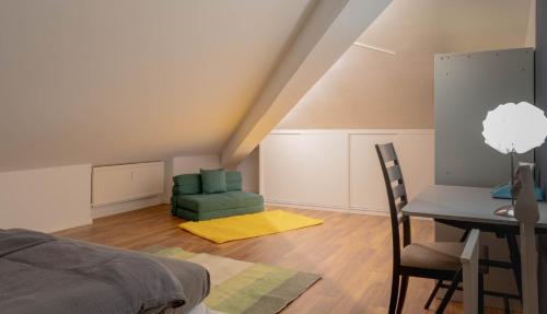 a bedroom with a green chair and a desk at Colombo Lodge Fvg in Tolmezzo
