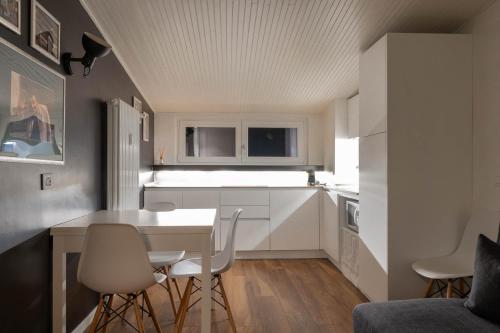a small kitchen with a white table and chairs at Colombo Lodge Fvg in Tolmezzo