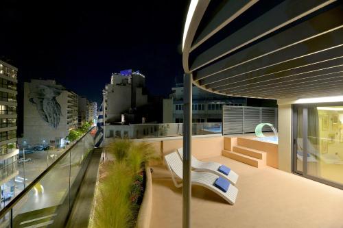 a balcony with a bench and a view of a city at Alva Athens Hotel in Athens