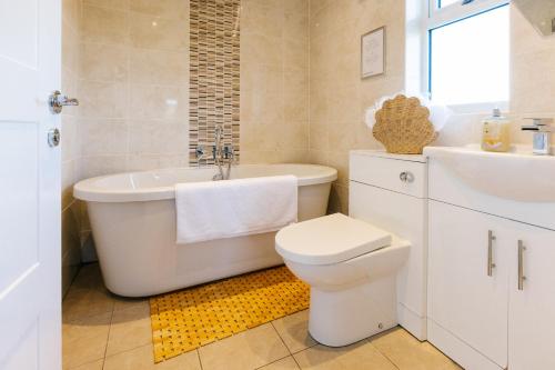 a bathroom with a tub and a toilet and a sink at James Ville Marina, Lodge 9 in Brigg