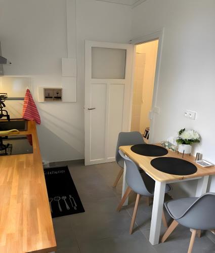 a room with a table and chairs and a door at Charmant Studio climatisé Paris Expo Porte de Versailles - Dôme de Paris - proche des transports in Vanves