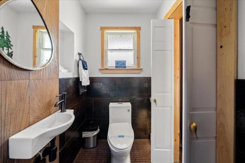 a bathroom with a toilet and a sink and a mirror at Green Acres Retreat in Hancock