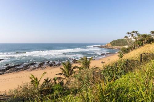 a sandy beach with the ocean in the background at Sala Beach House in Ballito