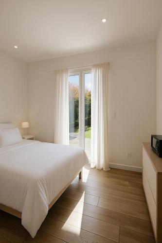 une chambre avec un lit et une grande fenêtre dans l'établissement Jolie villa avec piscine, à Monticello