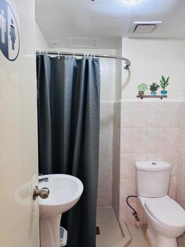 a bathroom with a shower with a toilet and a sink at Seawind Condominium in Davao City