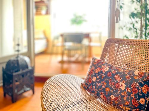 a pillow sitting on a chair in a living room at RétroMirabeau "Côté Mer" - 29m2 - LUMINEUX - TERRASSE Loggia - VUE MARINA - PARKING SECURISE - 2 à 3 pers - EMPLACEMENT TOP - Chèques Vacances CONNECT in Gruissan