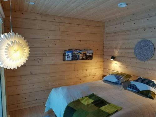 a bedroom with a bed in a wooden wall at Spacious Apartment for 8 with Sauna in Syöte
