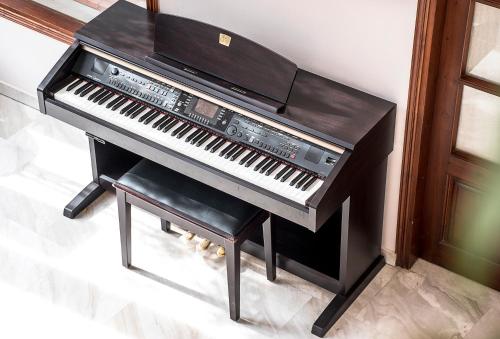 a black piano with a stool next to it at Fedriades Delphi Hotel in Delfoi