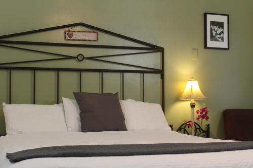 - une chambre avec un grand lit et des oreillers blancs dans l'établissement El Rancho Motel, à Bishop