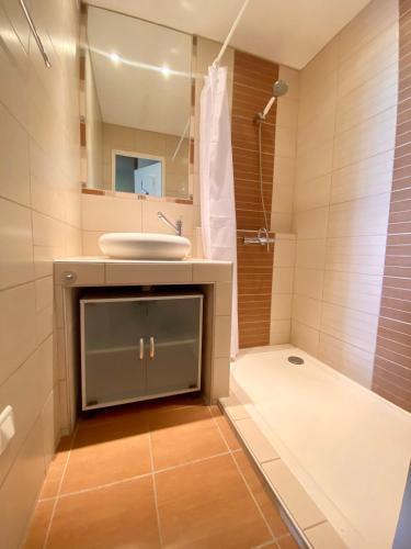 une salle de bain avec un lavabo et un miroir dans l'établissement LA GRANDE MOTTE – T2 VUE MER ET PINÈDE – 4 PERSONNES – PARKING PRIVATIF, à La Grande Motte