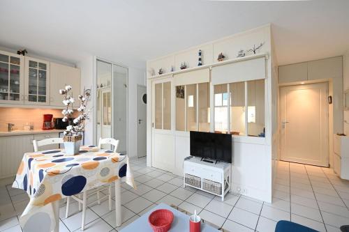 un salon avec une table et une cuisine dans l'établissement Vauban 179 - Mignon appartement, à Saint-Martin-de-Ré