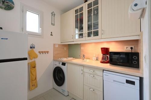 Il comprend une cuisine équipée d'un lave-linge, d'un évier et d'un four micro-ondes. dans l'établissement Vauban 179 - Mignon appartement, à Saint-Martin-de-Ré