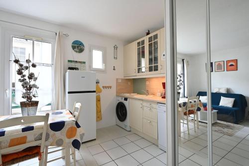 Il comprend une cuisine équipée d'un réfrigérateur, d'une table et de chaises. dans l'établissement Vauban 179 - Mignon appartement, à Saint-Martin-de-Ré