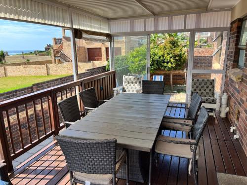 una mesa de madera y sillas en una terraza en Point Jbay, en Jeffreys Bay