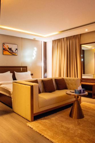 a living room with a couch and a table at W by Triple Tees Hotel and Suites in Mama