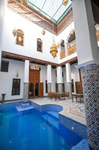 a pool in the middle of a building with a ceiling at Riad Old City Palace in Fès