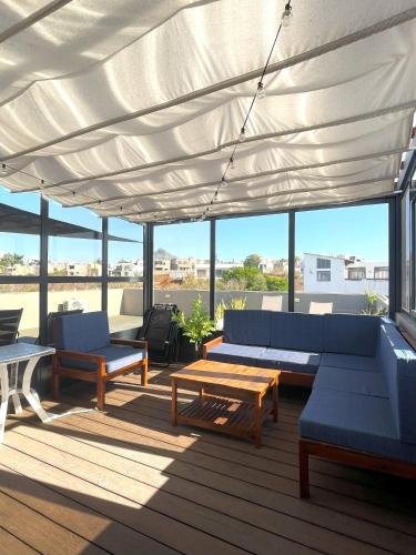 a patio with couches and tables on a deck at Appartement avec Rooftop privé et Jacuzzi in Albion