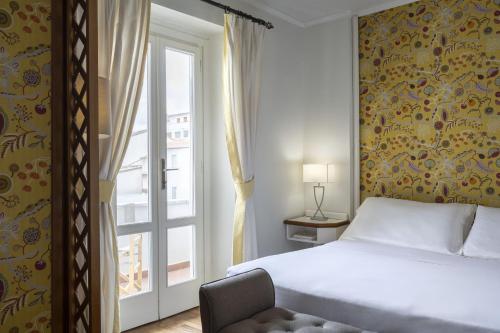 a bedroom with a bed and a window at Palace Hotel in Viareggio