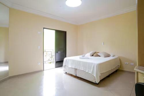 a bedroom with a white bed in a room at Suíte privativa 5 minutos metrô com Piscina e churrasqueira in Sao Paulo