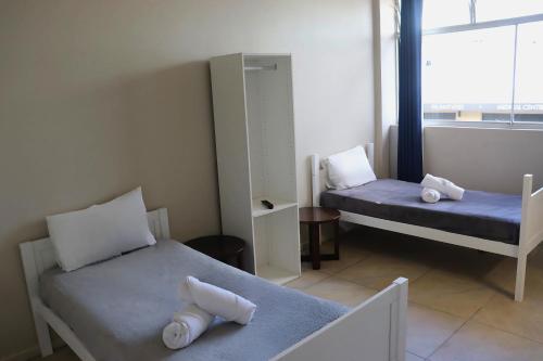 a small room with two beds and a mirror at SOPO Backpackers in Gold Coast