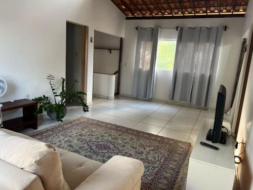 a living room with a couch and a tv at Casa aconchegante in Barra de Santo Antônio