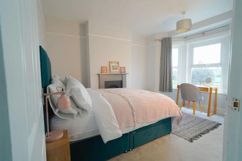 a bedroom with a bed and a desk and a window at Parkside View, Exeter in Alphington